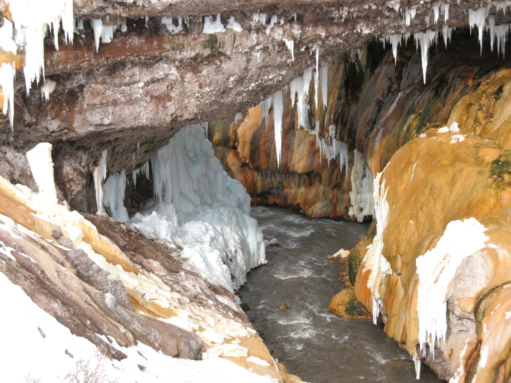 Puente del Inca zimą: łuk z rumoszu scementowanego osadami gorących źródeł, zabarwiony na żółto i pomarańczowo.